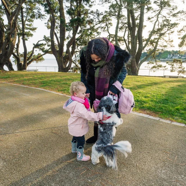 Klein meisje en haar moeder aaien een hond die ze tegenkwamen bij Pointe du Coq