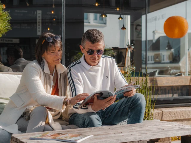 Paar schaut sich auf der Terrasse des Bateau Libre Hôtel - Bar à vin & Cocktail eine Zeitschrift an