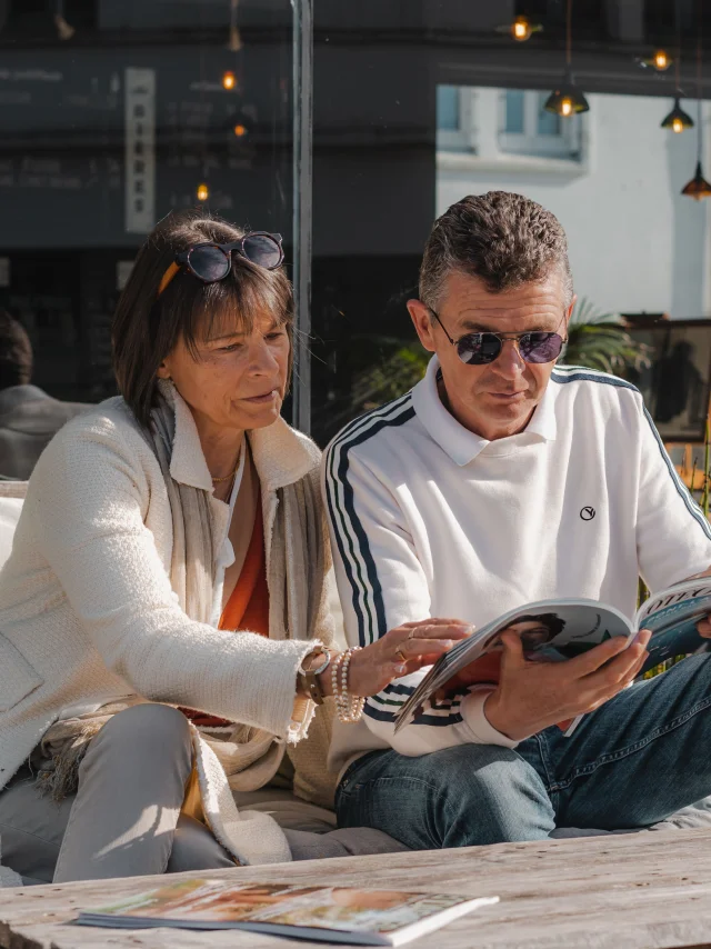 Paar schaut sich auf der Terrasse des Bateau Libre Hôtel - Bar à vin & Cocktail eine Zeitschrift an