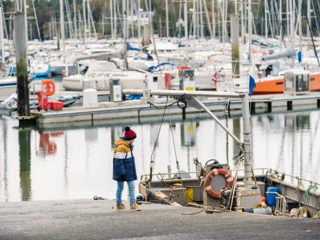Little boy watching a boat in the Bénodet marina