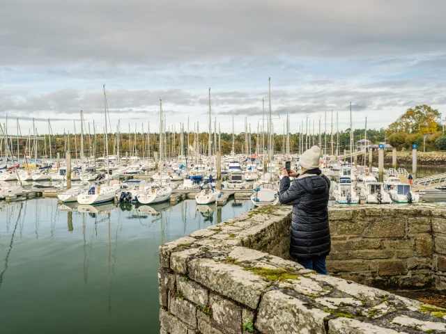 Visitor taking a photo of the Bénodet marina