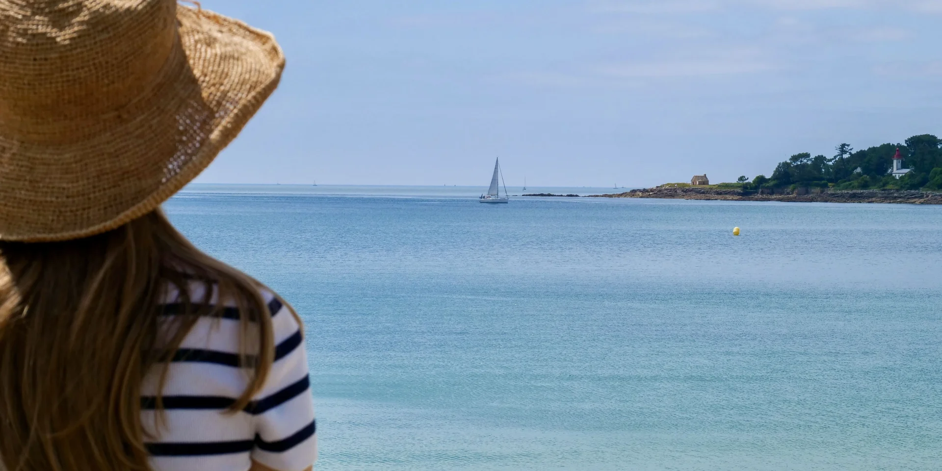 Young woman admiring the Pointe de Combrit from the Plage du Trez in Bénodet