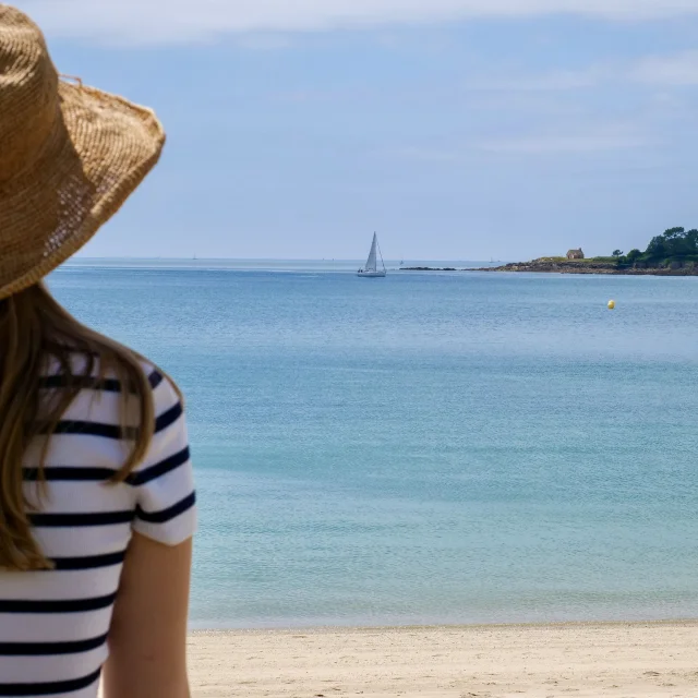Young woman admiring the Pointe de Combrit from the Plage du Trez in Bénodet