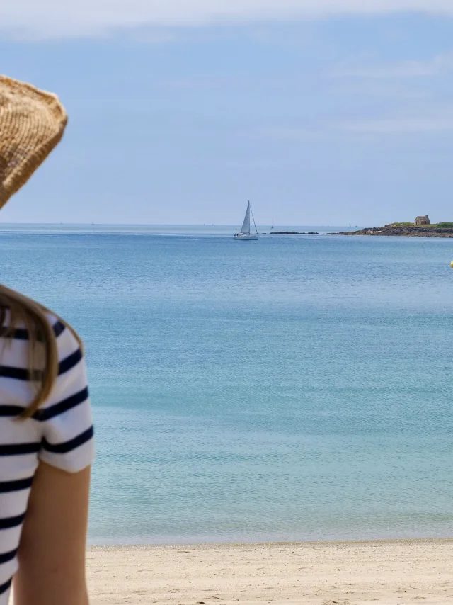 Jonge vrouw bewondert de Pointe de Combrit vanaf het Plage du Trez in Bénodet