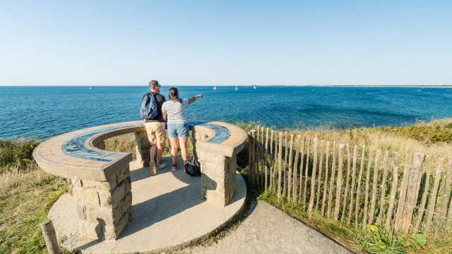 Couple admiring the horizon at the Pointe de Groasguen orientation table in Bénodet