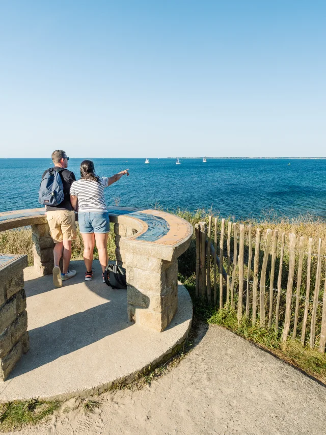 Couple admiring the horizon at the Pointe de Groasguen orientation table in Bénodet