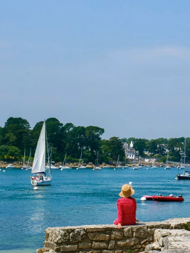 Jonge vrouw zittend bij de vuurtoren van Coq in Bénodet