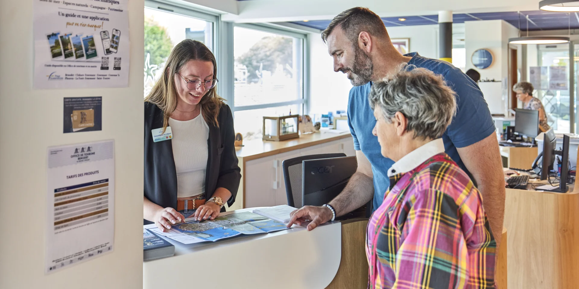 Conseillère en séjour renseignant des visiteurs à l'Office de Tourisme de Bénodet