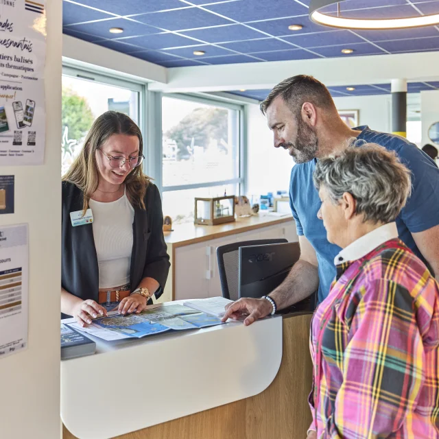 Conseillère en séjour renseignant des visiteurs à l'Office de Tourisme de Bénodet