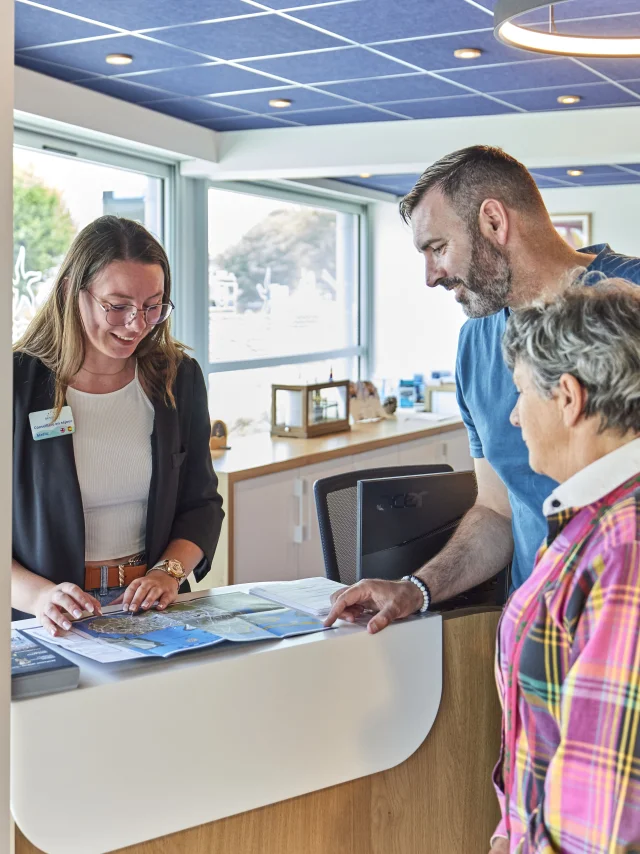 Vakantie-adviseur die informatie verstrekt aan bezoekers van het toeristenbureau van Bénodet