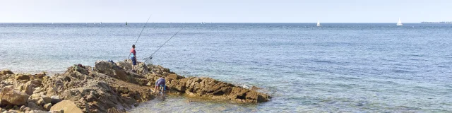 Twee mannen vissen voor Pointe Saint-Gilles