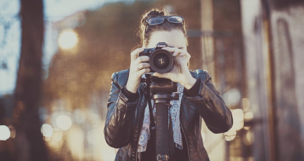 Girl taking a photo behind her lens