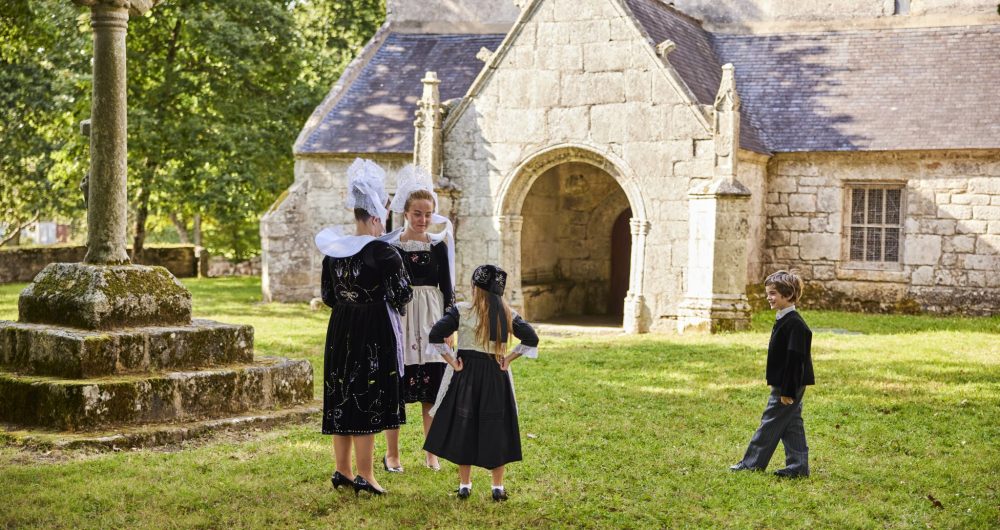 Perguet kerk en kinderen in traditionele klederdracht