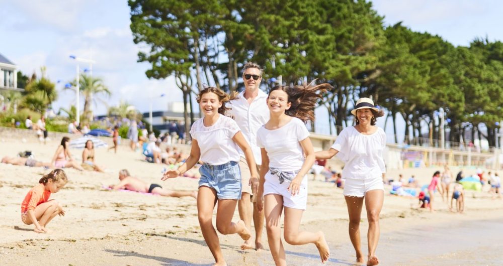Famille courant dans l'eau à la Plage du Trez de Bénodet