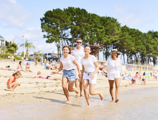 Famille courant dans l'eau à la Plage du Trez de Bénodet